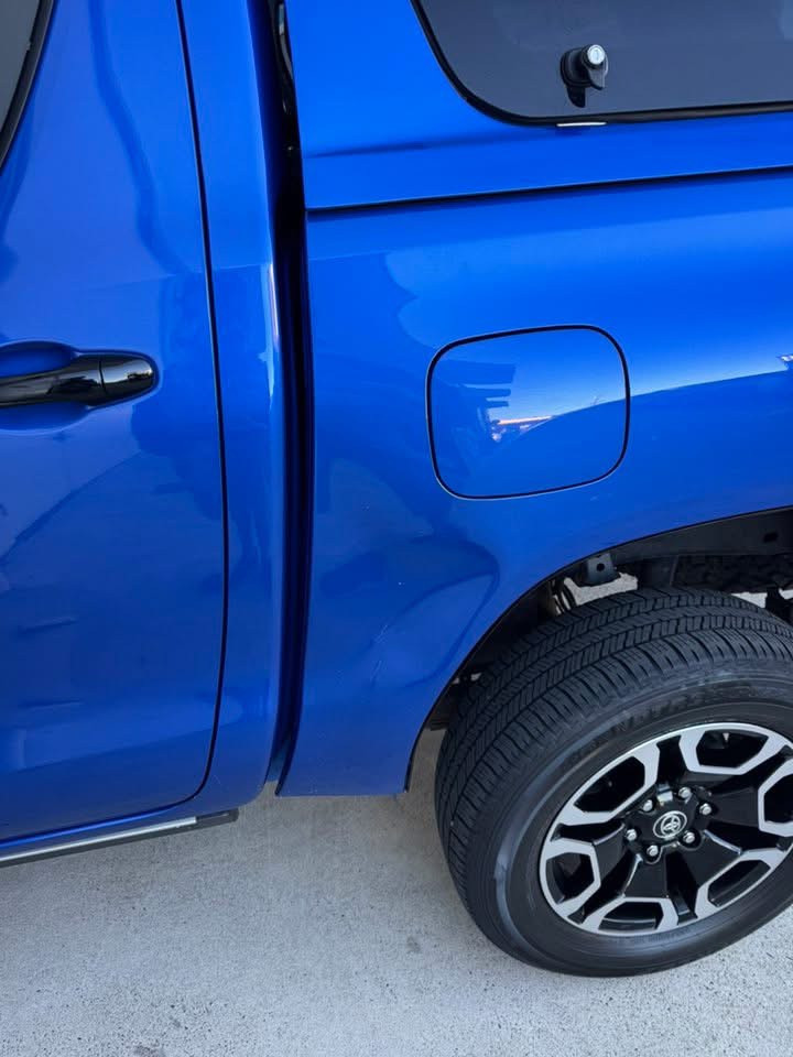 Wider view of the blue Toyota ute rear quarter panel after repair