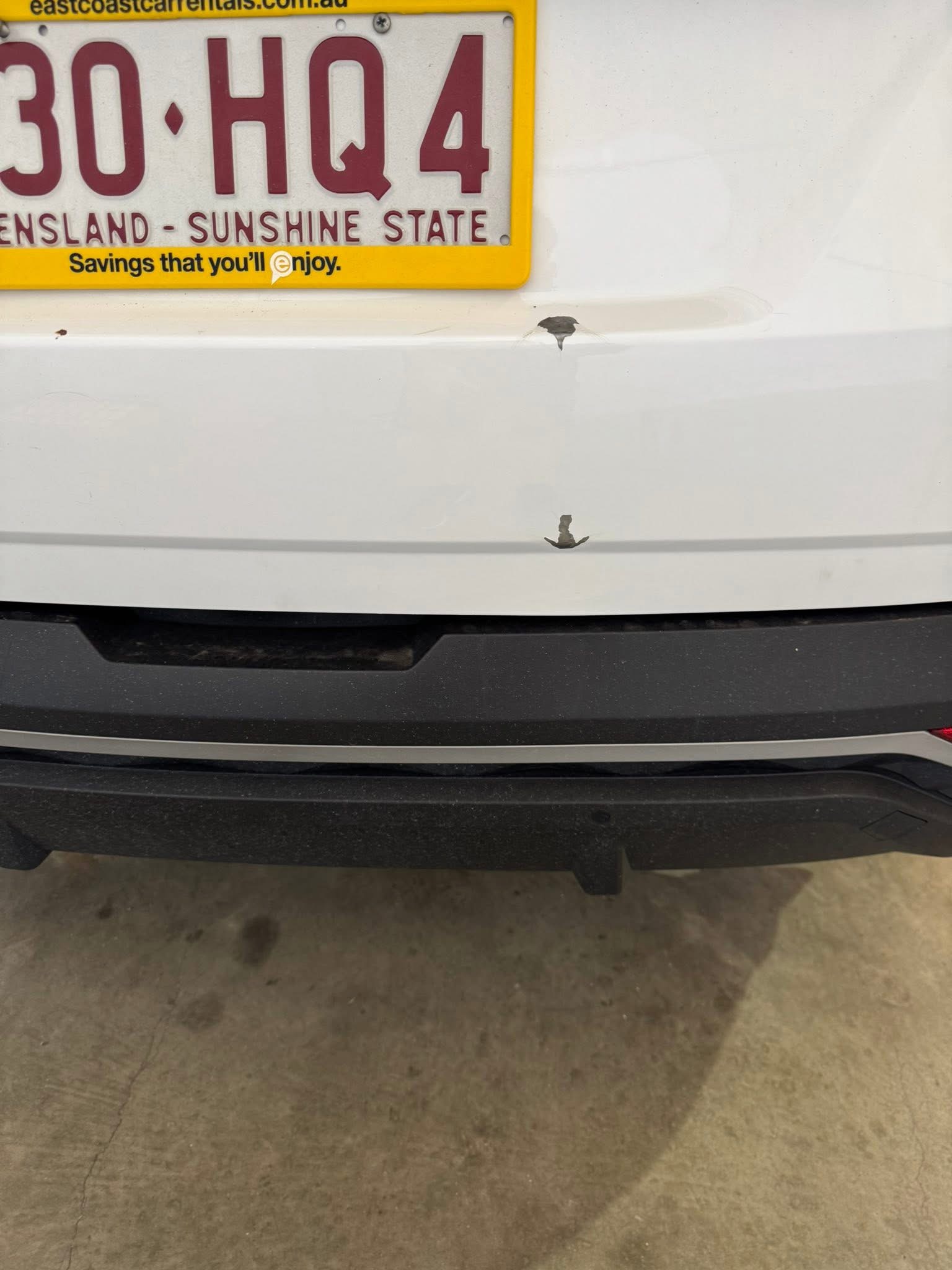 Before repair: close view of the dent and damaged paint on the rear hatch