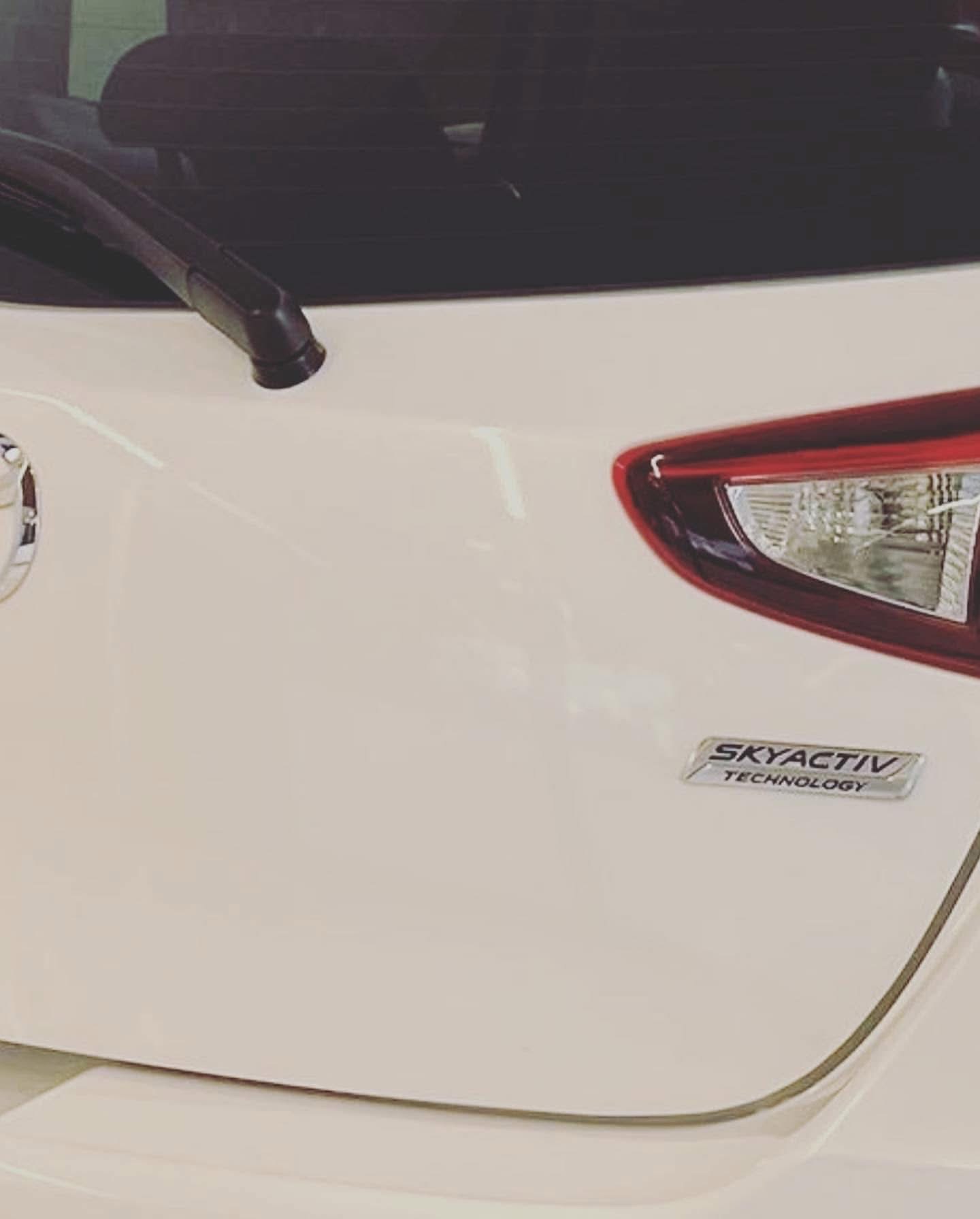 After repair: finished white Mazda rear hatch near the right tail light
